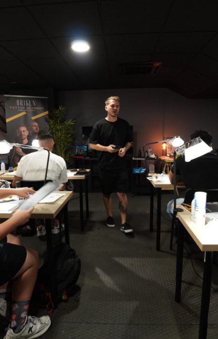 Aula de formación de Origen Tattoo Academy con alumnos practicando en sus mesas, Tenerife